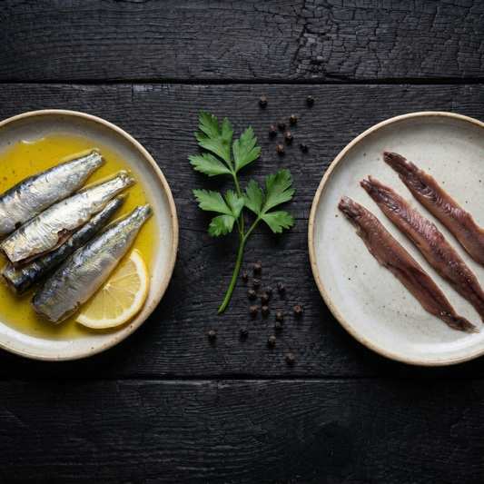 Difference between sardines and anchovies — open tins of sardines in olive oil and Cantabrian anchovy fillets side by side